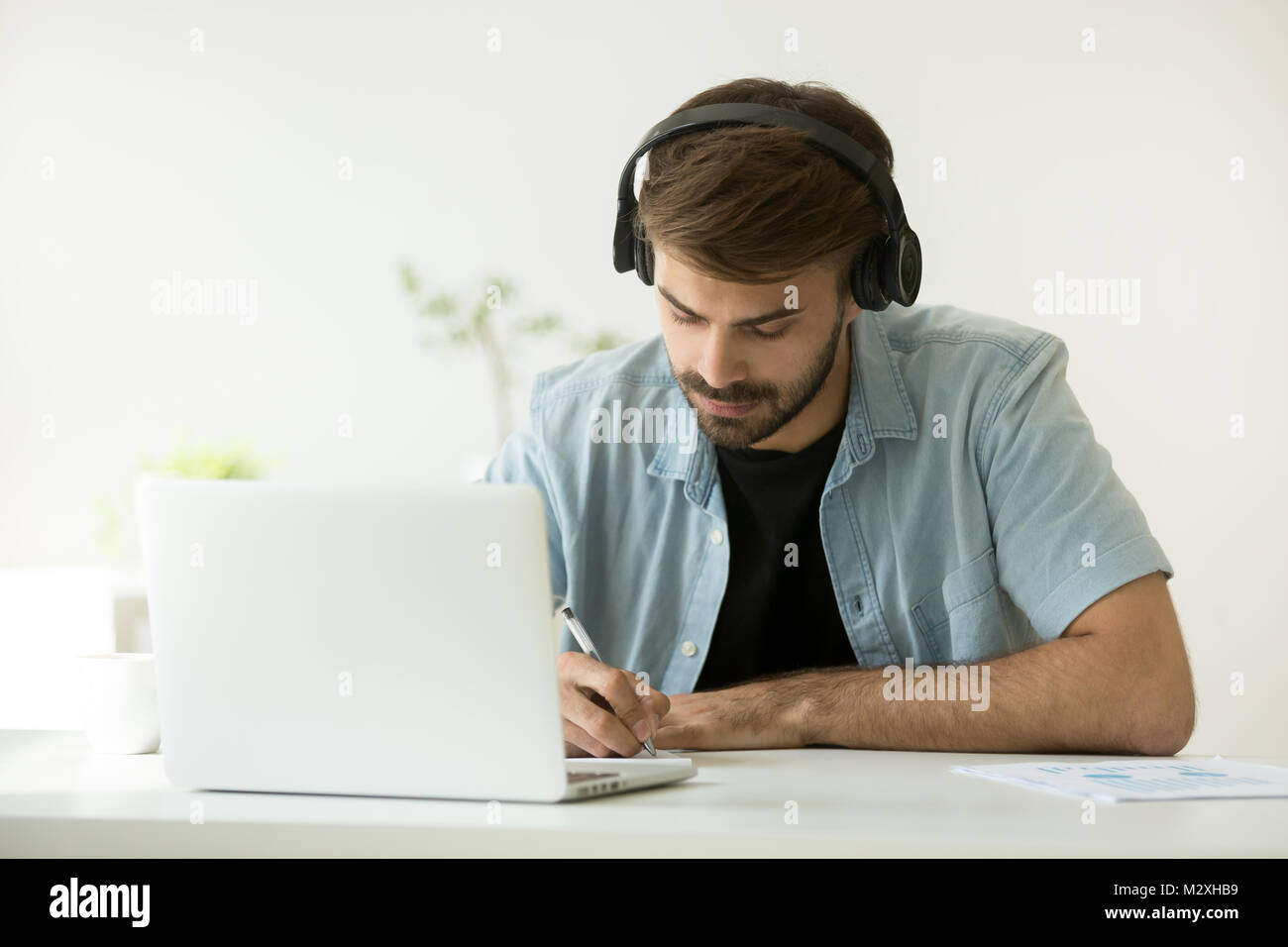 Fokussiert man das Tragen von Kopfhörern Notizen online lernen wit Stockfoto