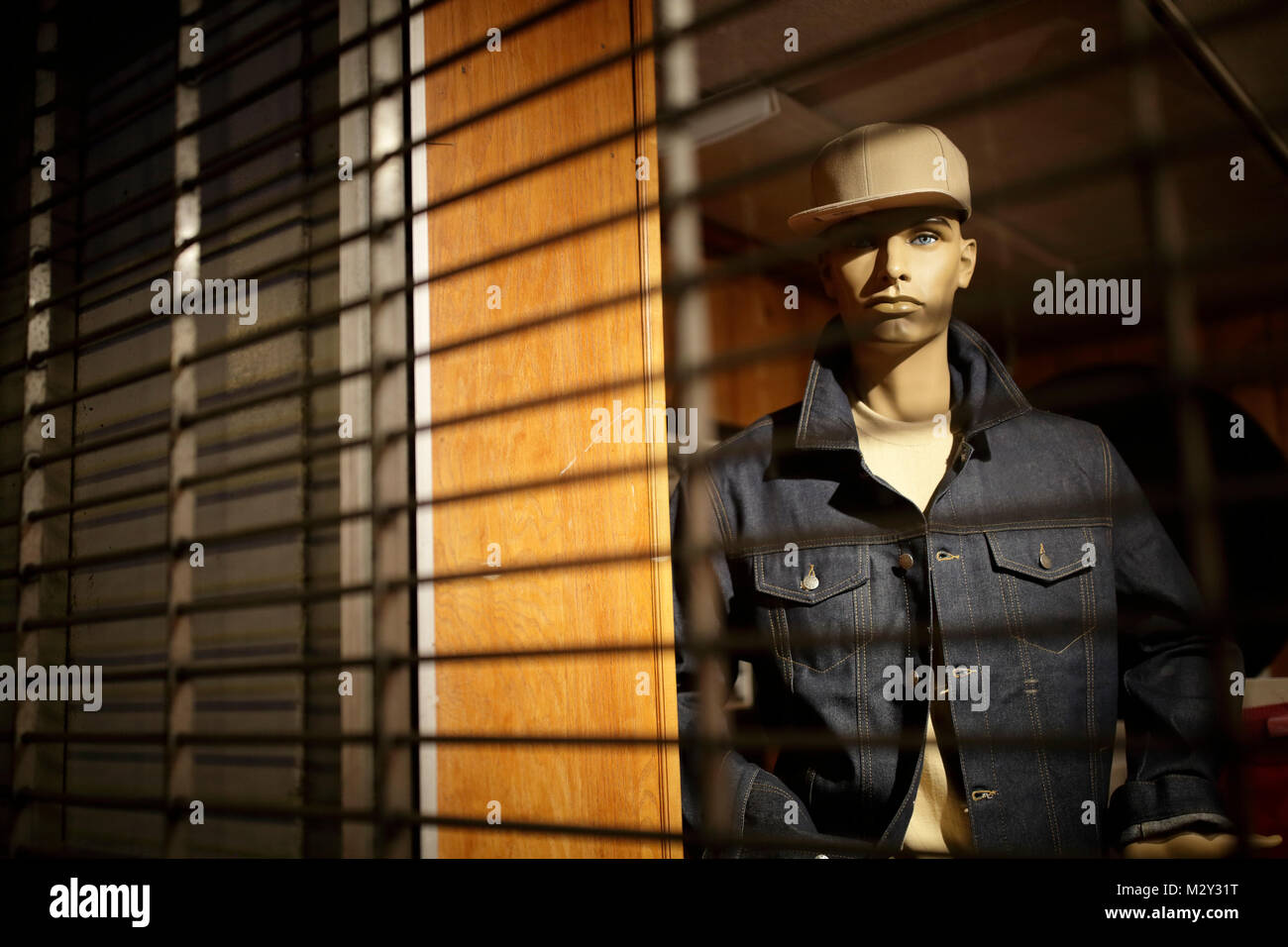 Urban mannequin hinter storefront Sicherheit Bars, USA Stockfoto