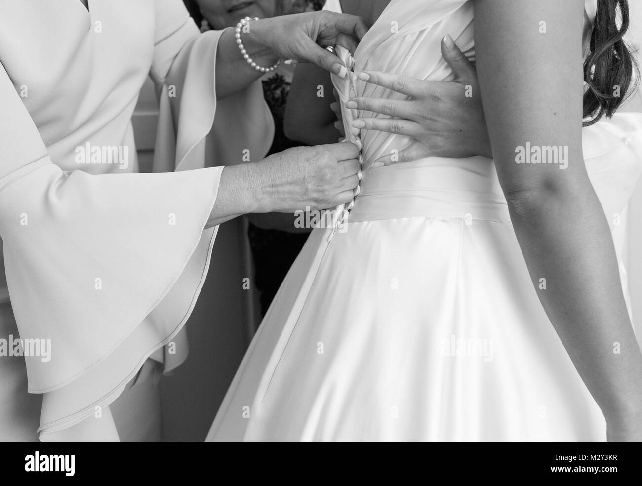 Mutter der Braut knöpfte Tochter Hochzeitskleid Stockfoto