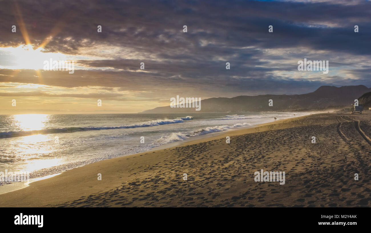 Schöne Küsten Sonnenuntergang auf eine leere Stelle Dume State Beach mit bunten Wolken im Himmel und der Santa Monica Mountains im Hintergrund, Malibu, Kalifornien Stockfoto