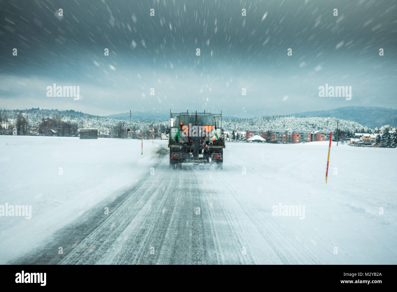 Winter service Lkw oder Streuer Salz Verbreitung auf der Fahrbahn Vereisung in stürmischen schnee winter Tag zu verhindern. Stockfoto