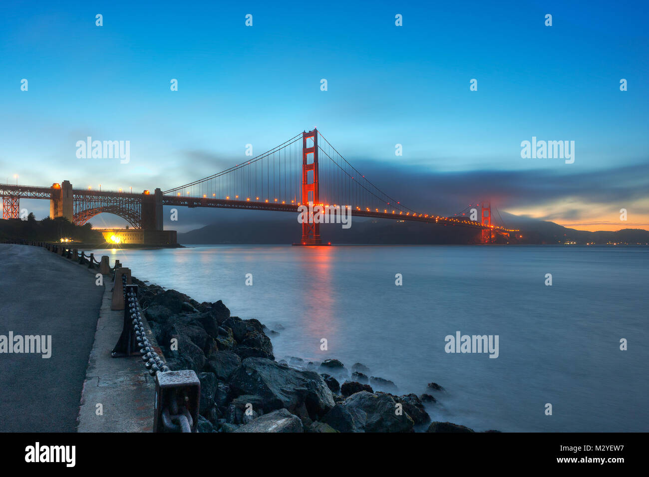 Die berühmte Golden Gate Bridge mit dem Fort Point National Historic Site fotografiert nach Sonnenuntergang aus San Francisco Bucht in San Francisco, CA. Stockfoto