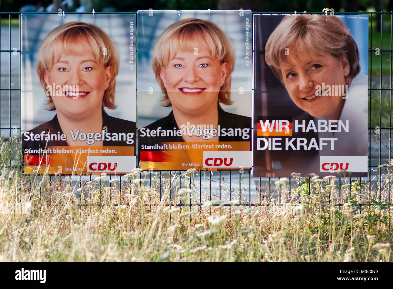 Wahlplakate ein einen Zaunauf dem Mittelstreifen. Stockfoto