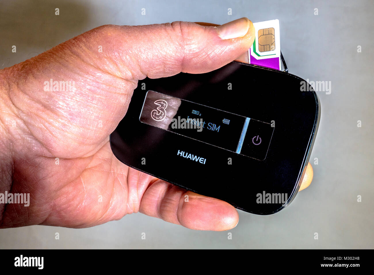 Des Menschen Hand drei Daten Trio (drei Größen) SIM-Karte, die in einen  Huawei Mobile wlan-Router eingesetzt wird, mobiles Breitbandgerät. England,  UK Stockfotografie - Alamy
