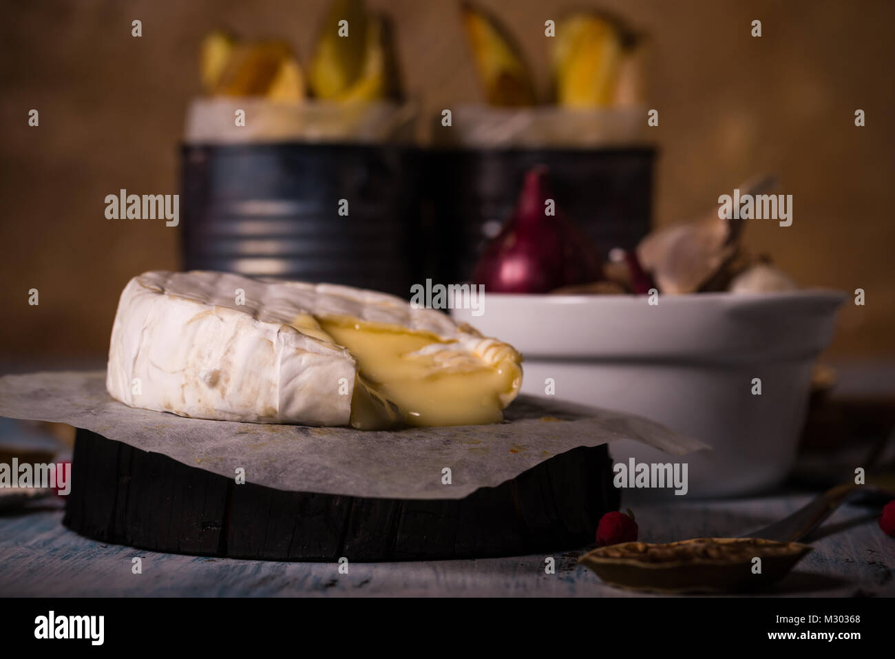 Horizontale Foto mit ganze gegrillte camambert Käse. Kleines Dreieck Stück abgeschnitten und geschmolzenem Käse ist variabel. Bratkartoffeln und Farbe onio Stockfoto