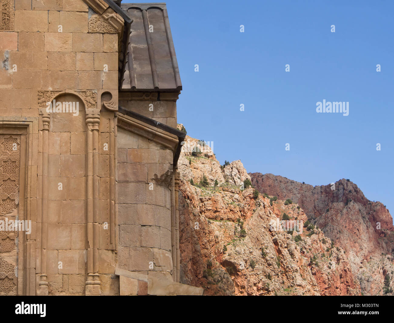 Kloster Noravank im südlichen Armenien, Detail der Fassade der Surb Astvatsatsin Kirche mit roten Felswände und blauer Himmel Stockfoto