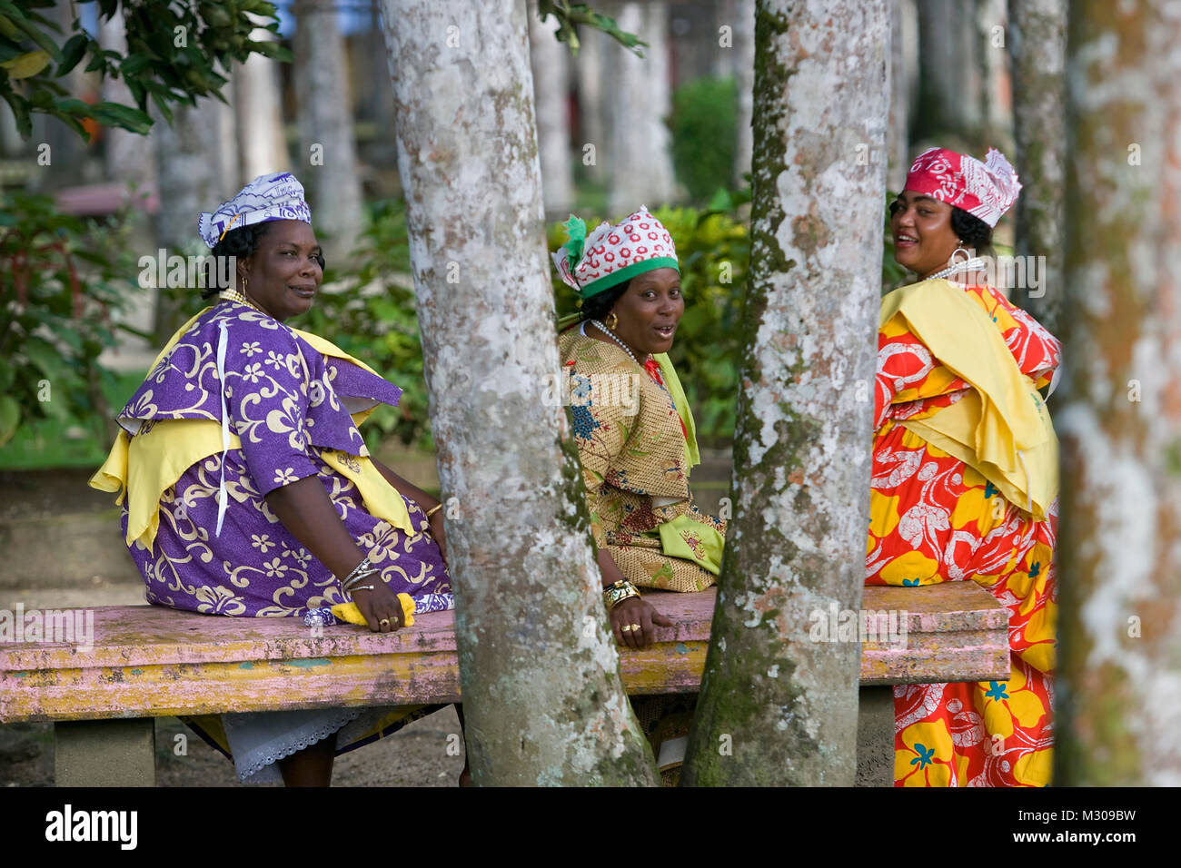 Suriname, Paramaribo. Kreolische Frauen in Kotomisi Kleid, die kreolische Tracht im Palmengarten. Stockfoto