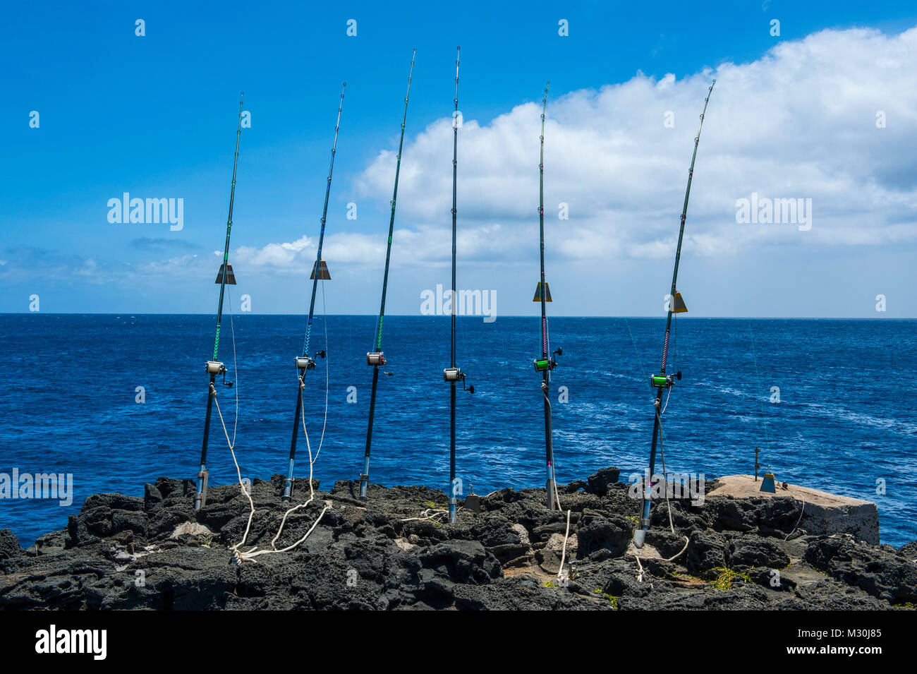 Angeln Stangen auf einen Felsen, Kalae, South Point, der südlichste Punkt der Großen Insel, Hawaii Stockfoto