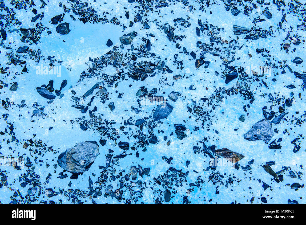 Steine in das blaue Eis des Fox Glacier, South Island, Neuseeland eingefroren Stockfoto