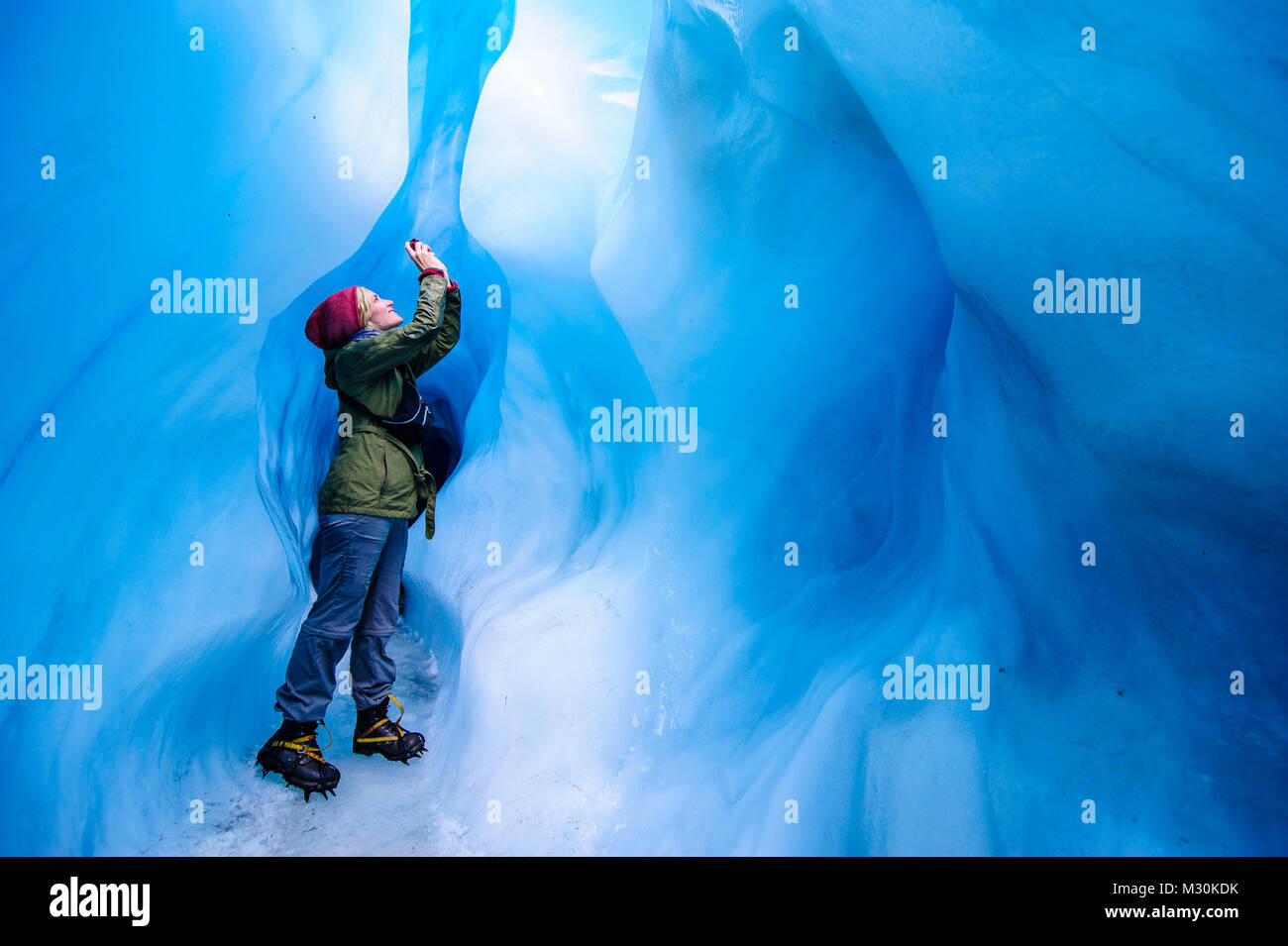 Frau fotografieren in einer Eishöhle in Fox Glacier, South Island, Neuseeland Stockfoto