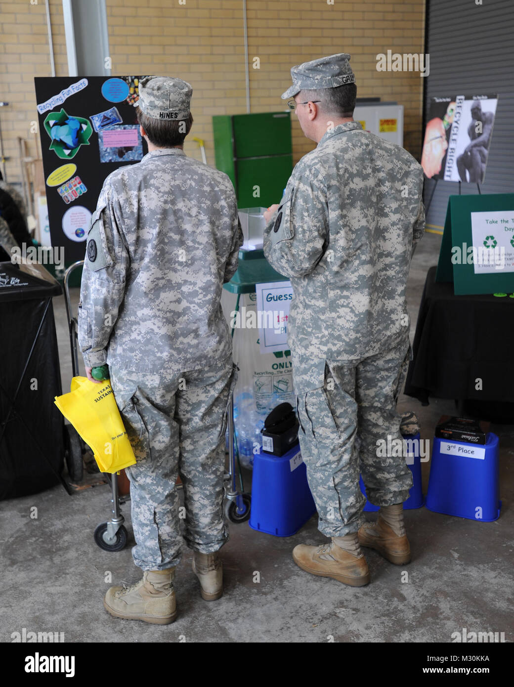 Colonel Elizabeth Hines, und Staff Sgt. James D. Grau, beide mit J4 (Logistik) am Lager Mabry, in Austin, bis zum Recycling an der Eröffnung des Camp Mabry Recycling Center am November 15, 2012. Das Recycling Center stellt die laufende Verpflichtung der TXMF zu Nachhaltigkeit in der Gemeinschaft, die Annahme von Papier, Metall, Kunststoff und anderen Wertstoffen. (National Guard Foto von Army Staff Sgt. Jennifer D. Atkinson/Freigegeben) 121115-Z-JR 121-004 Texas Streitkräfte Recycling Center von Texas militärische Abteilung Stockfoto