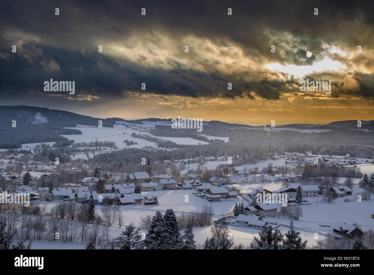 Sonnenuntergang mit dramatischen Himmel über die winterliche Landschaft in der Nähe von Neuschönau im Nationalpark Bayerischer Wald in Bayern, Deutschland. Stockfoto