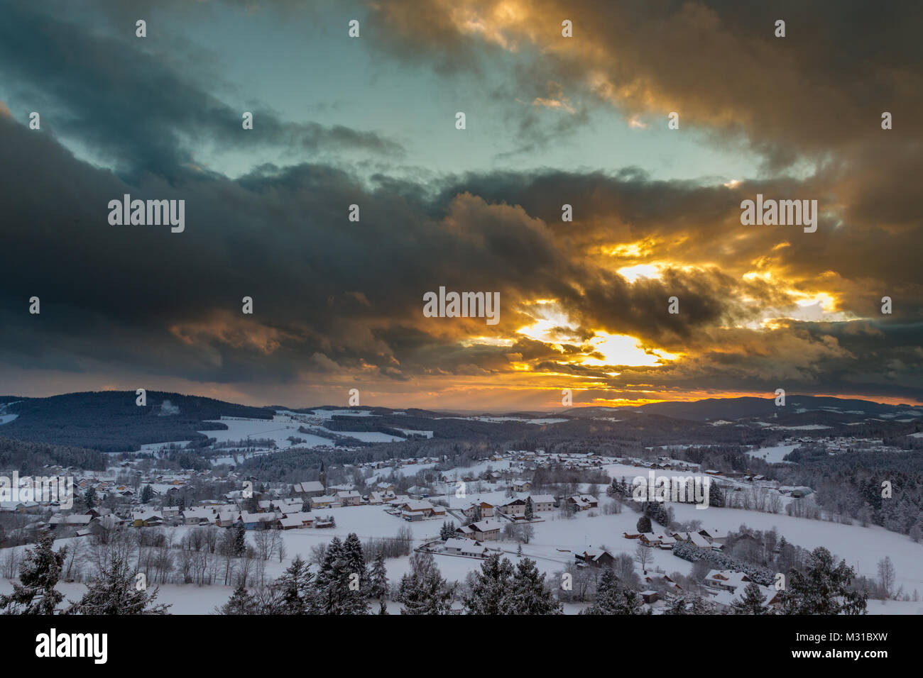 Sonnenuntergang mit dramatischen Himmel über die winterliche Landschaft in der Nähe von Neuschönau im Nationalpark Bayerischer Wald in Bayern, Deutschland. Stockfoto