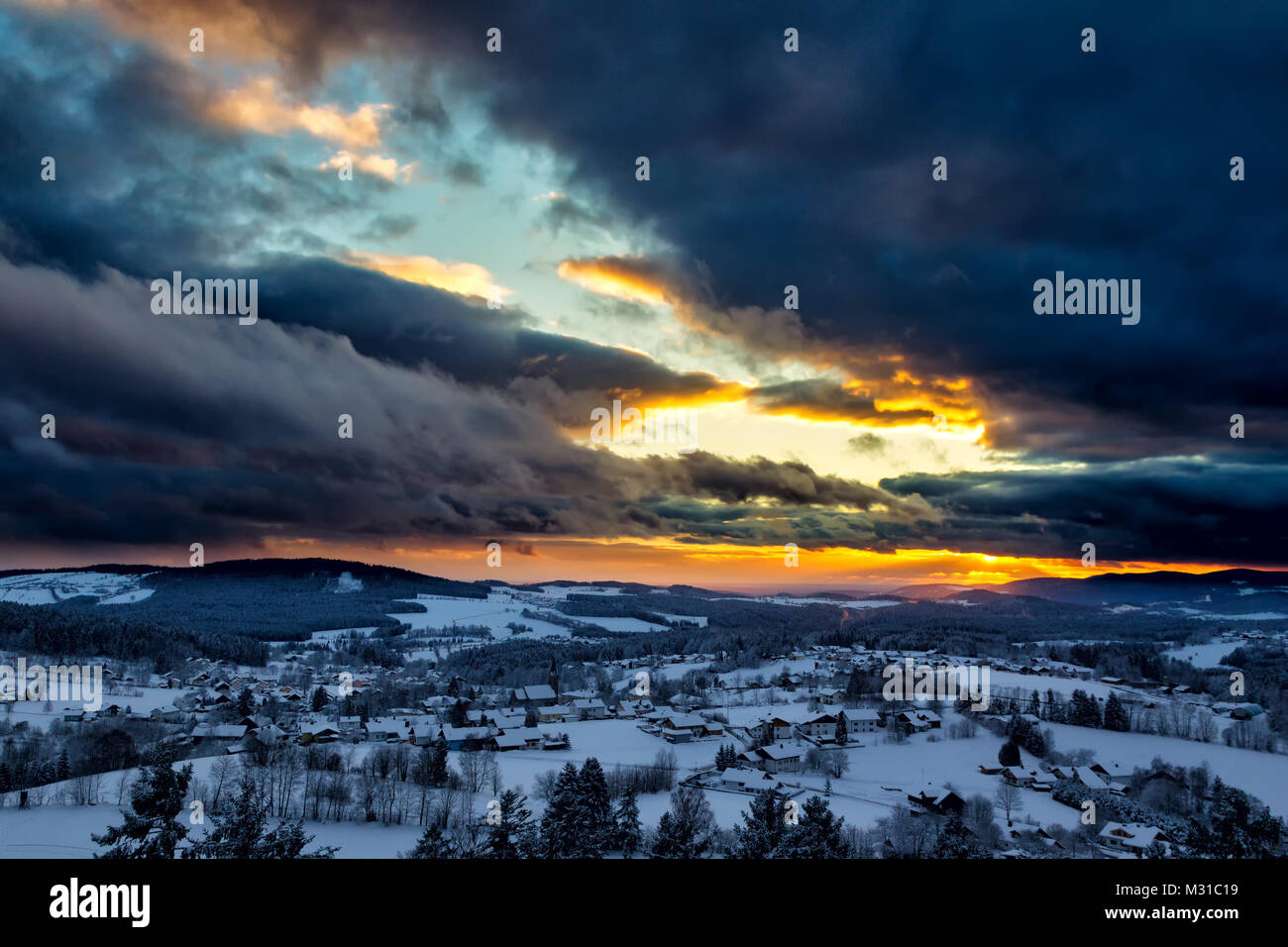Sonnenuntergang mit dramatischen Himmel über die winterliche Landschaft in der Nähe von Neuschönau im Nationalpark Bayerischer Wald in Bayern, Deutschland. Stockfoto