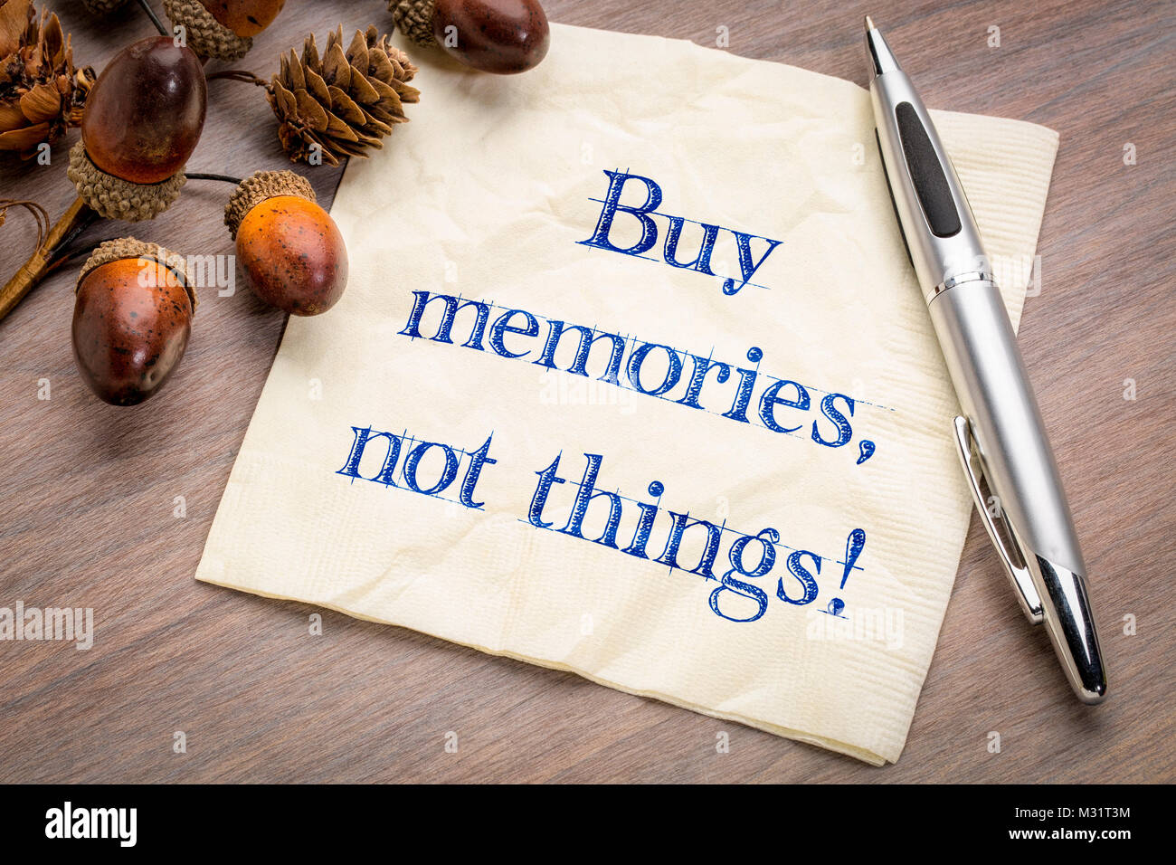 Kaufen Erinnerungen, die Dinge nicht! Inspirational Handschrift auf einem napking mit Acorn decotation. Stockfoto
