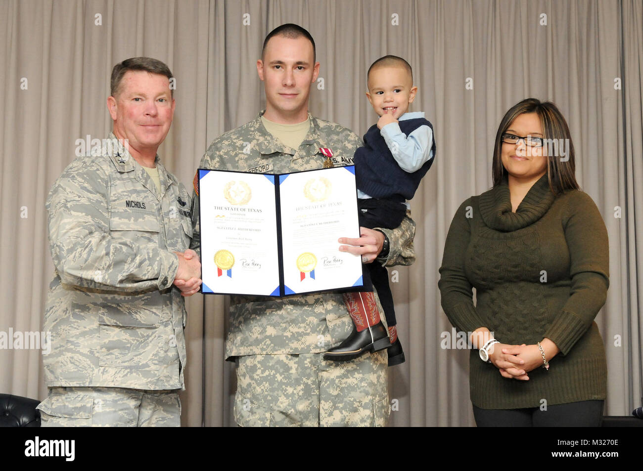 Generalmajor John F. Nichols, der Adjutant General von Texas, Links, präsentiert Staff Sgt. Clint F. Rutherford, Texas Army National Guard, mit einem Staat Texas militärischen Ruhestand Zertifikat an seiner Promotion/Ruhestand Zeremonie am Lager Mabry in Austin, TX, Nov. 23, 2013 statt. Rutherford hat auch das Purple Heart Preis zweimal in früheren Zeremonien ausgezeichnet. (U.S. Army National Guard Foto von Master Sgt. Walker). 131123 A-BQ 644-0160 durch Texas militärische Abteilung Stockfoto