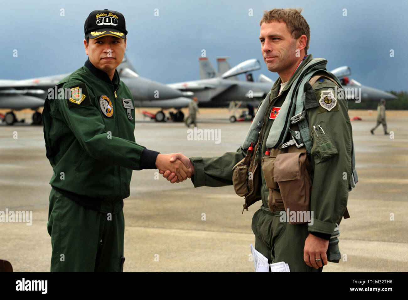 Japanische Luft Self Defense Force Oberstleutnant Miyake Hideaki, 306 Tactical Fighter Squadron Commander und US Air Force Oberstleutnant Morris Fontenot, 67th Fighter Squadron Commander, Hände schütteln während einer Pressekonferenz am Komatsu Air Base, Japan, Dez. 7, 2013. Beide Staffeln wird in einer Woche teilnehmen - lange bilaterale Aviation Training Relocation bewirtet durch die Jasdf 6 Flügel. Das Programm betont die Interoperabilität zwischen US-amerikanischen und japanischen Truppen, während die Förderung der Einsatzbereitschaft. (U.S. Air Force Foto: Staff Sgt. Bernstein E.N. Jacobs) JASDF uns Mitglied schüttelt die Hände vor für eine Stockfoto