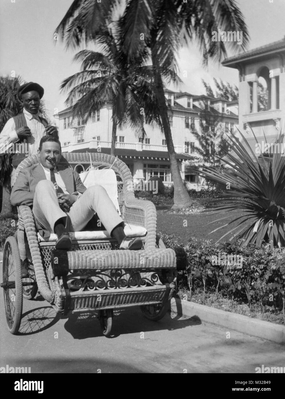 Ein Tourist ist um einen Resort in Florida in einem Korb Warenkorb durch einen afrikanischen amerikanischen Fahrer mit Rädern, Ca. 1948. Stockfoto