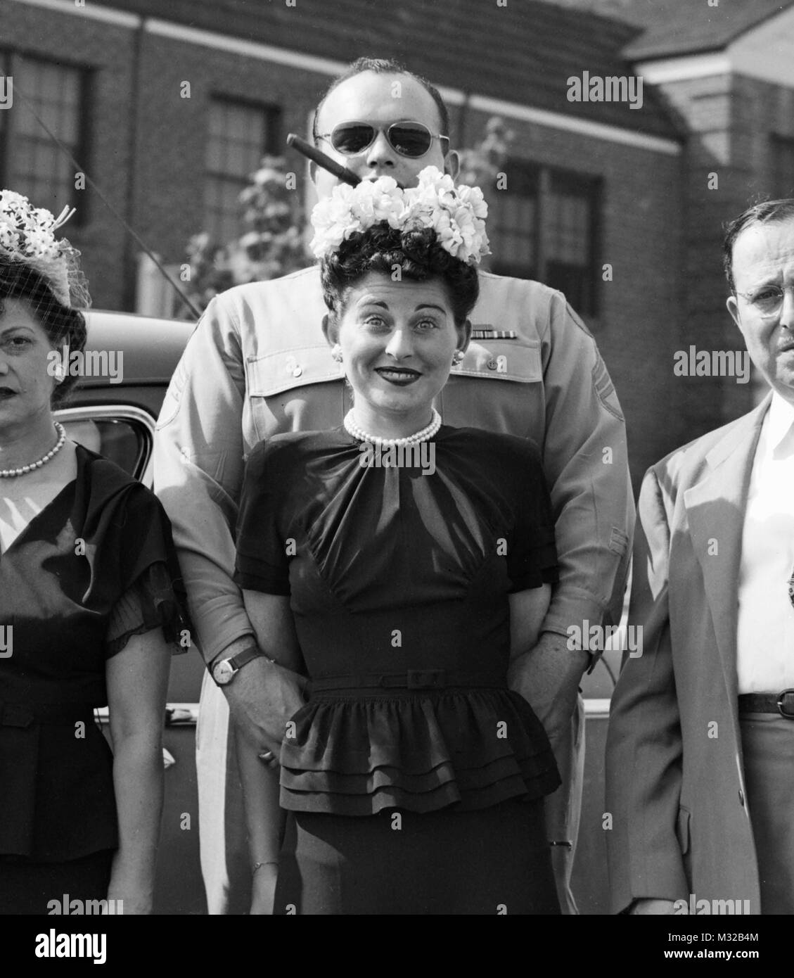 US Serviceman und seine Mädchen haben ein goofy Pose beim Stehen mit den Eltern für eine Fotografie,, Ca. 1944. Stockfoto