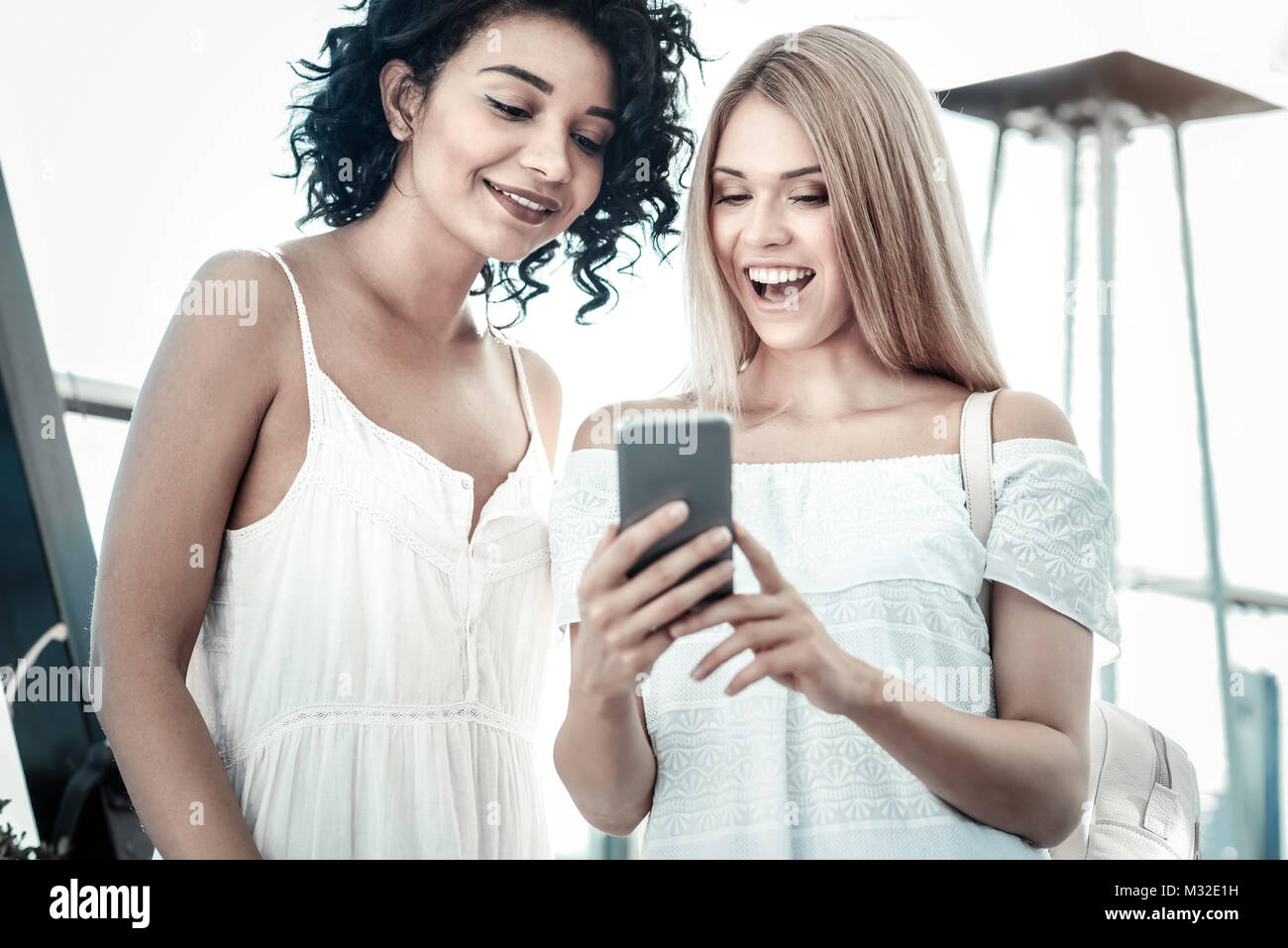 Freudige positive Frauen an den Bildschirm des Smartphones auf der Suche Stockfoto