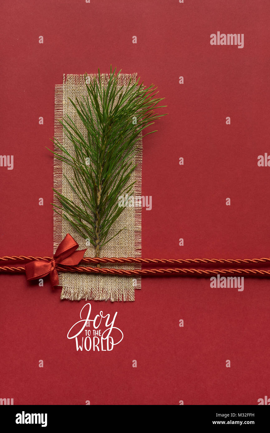 Kreatives Konzept Foto von einem Weihnachtsbaum Zweig auf rotem Hintergrund. Stockfoto