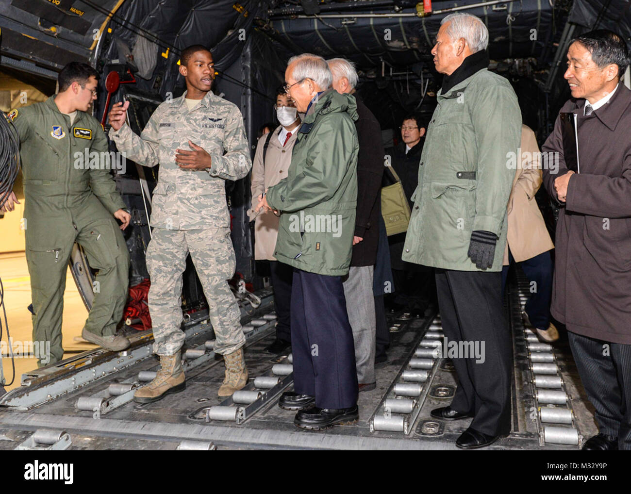 Airman 1st Class Adrian Robinson, 36th Airlift Squadron Lademeister, erklärt viele Funktionen in einer C-130 für die Mitglieder der Japanischen Gesellschaft für Sicherheit und Krisenmanagement bei Yokota Air Base, Japan, Feb 4, 2014. Japan Society Mitglieder tourte das Innere einer C-130, der Feuerwehr und der Emergency Operations Center. (U.S. Air Force Foto von Airman 1st Class Soo C. Kim/Freigegeben) Mitglieder der Japanischen Gesellschaft für Sicherheit und Krisenmanagement Tour der C-130 durch # FIRMA PACOM Stockfoto
