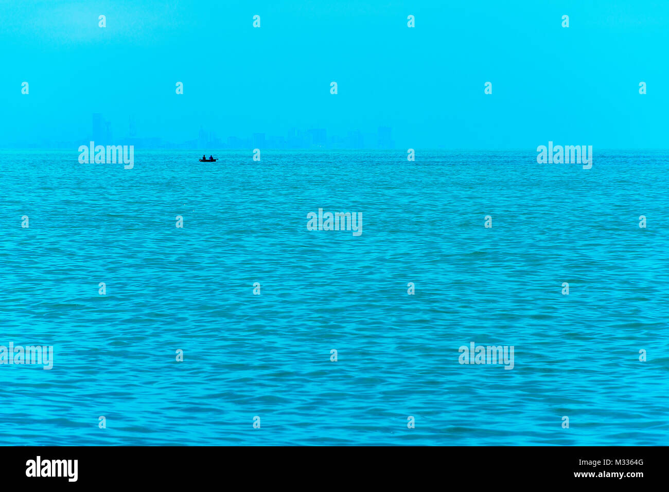 Angeln Boot im Vordergrund mit fogy Meer und die Skyline im Hintergrund. Stockfoto