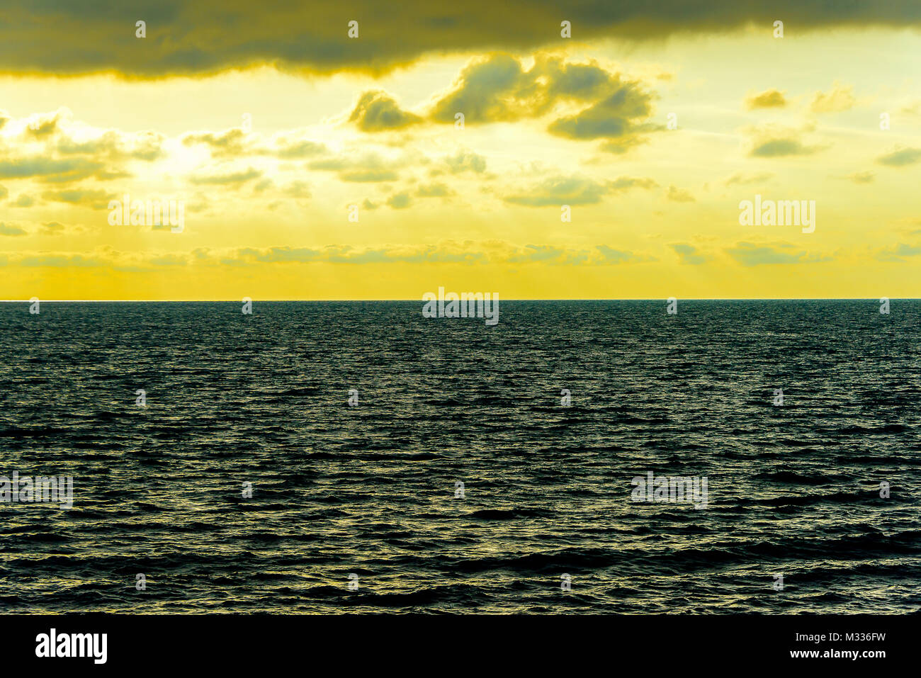 Stilisierte abstrakte Landschaft seascape Sonnenuntergang lange Belichtung mit Wolken unter verschiedenen Schattierungen von Blau, Orange, Gelb und Rot Stockfoto