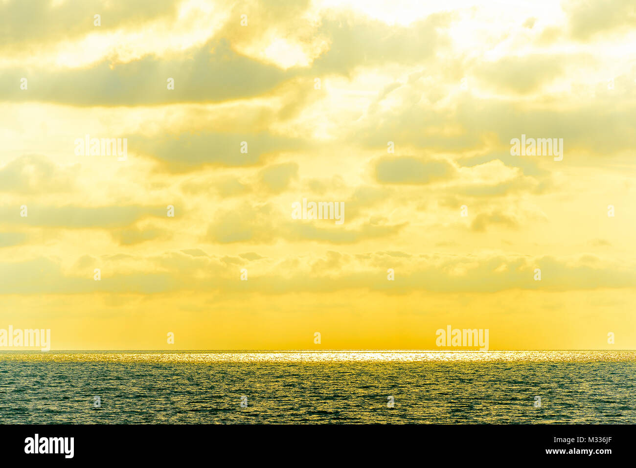 Stilisierte abstrakte Landschaft seascape Sonnenuntergang lange Belichtung mit Wolken unter verschiedenen Schattierungen von Blau, Orange, Gelb und Rot Stockfoto