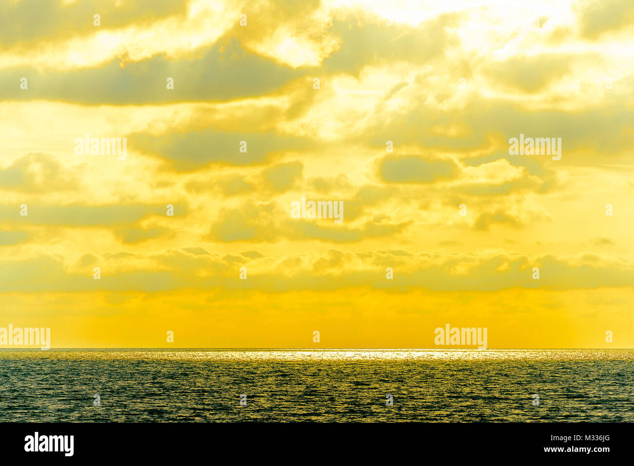 Stilisierte abstrakte Landschaft seascape Sonnenuntergang lange Belichtung mit Wolken unter verschiedenen Schattierungen von Blau, Orange, Gelb und Rot Stockfoto