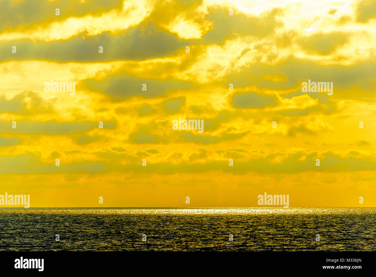 Stilisierte abstrakte Landschaft seascape Sonnenuntergang lange Belichtung mit Wolken unter verschiedenen Schattierungen von Blau, Orange, Gelb und Rot Stockfoto