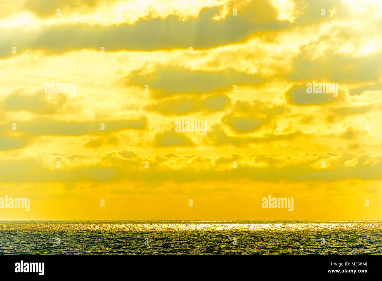 Stilisierte abstrakte Landschaft seascape Sonnenuntergang lange Belichtung mit Wolken unter verschiedenen Schattierungen von Blau, Orange, Gelb und Rot Stockfoto