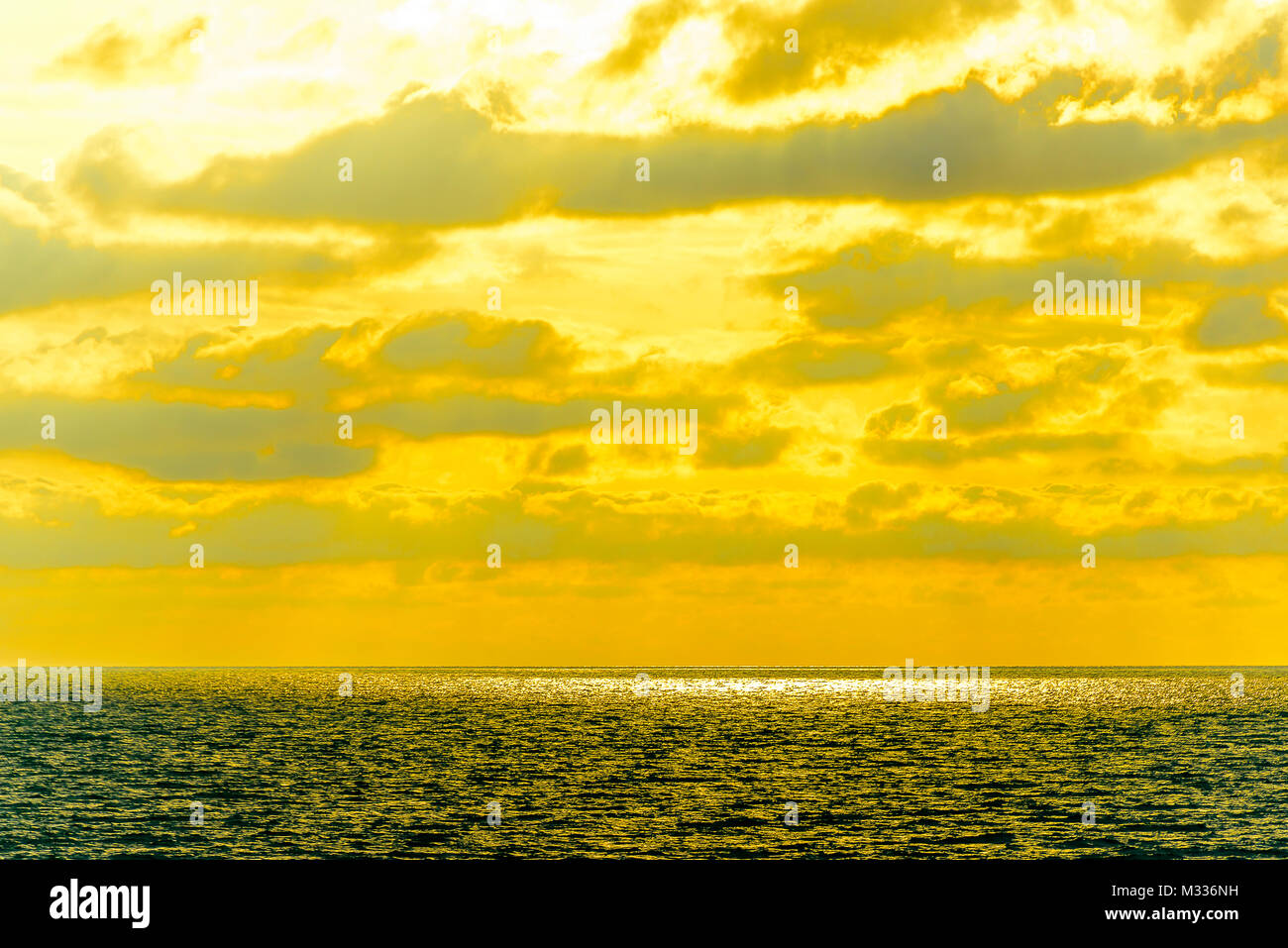 Stilisierte abstrakte Landschaft seascape Sonnenuntergang lange Belichtung mit Wolken unter verschiedenen Schattierungen von Blau, Orange, Gelb und Rot Stockfoto