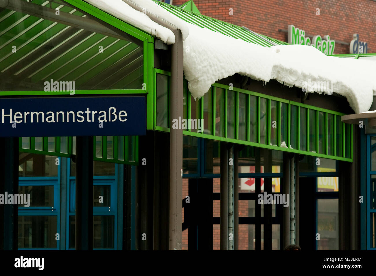 Gefährliche Schneebretter drohen vom Glasdach am Berliner S-Bahnhof Hermannstraße auf Passanten zu gefallen. Stockfoto