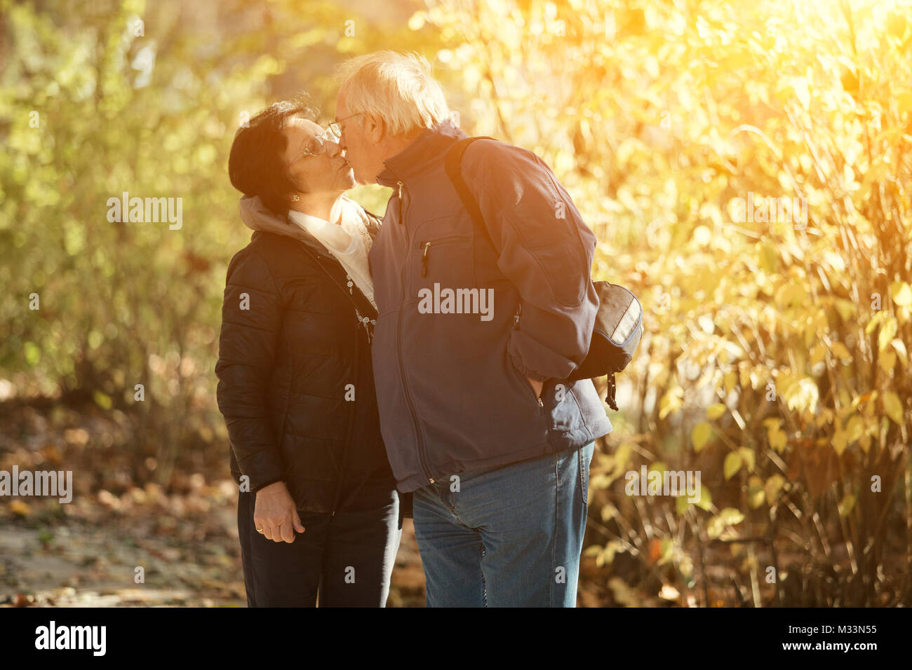 Senior paar Küssen und genießen die Zeit im Park auf den Sonnenuntergang. Concerpt Familie Stockfoto