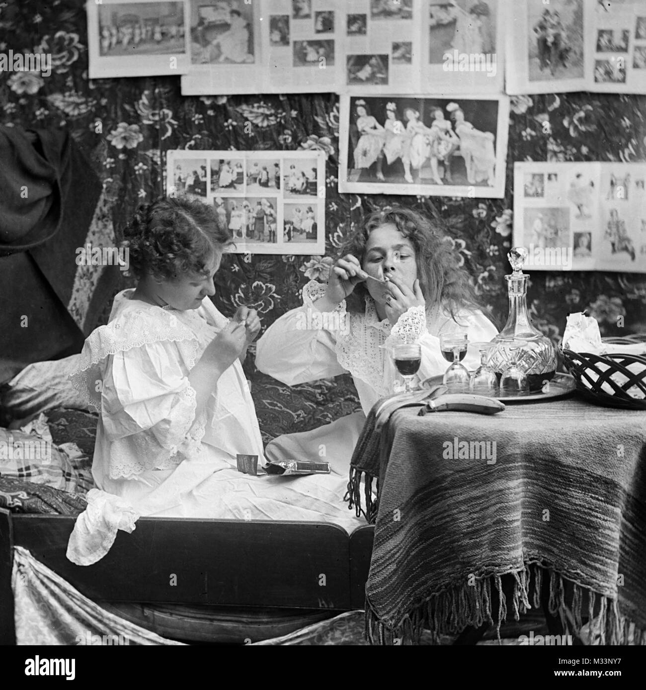 Zwei junge Frauen trinken und rauchen im Bett, Ca. 1910. Stockfoto