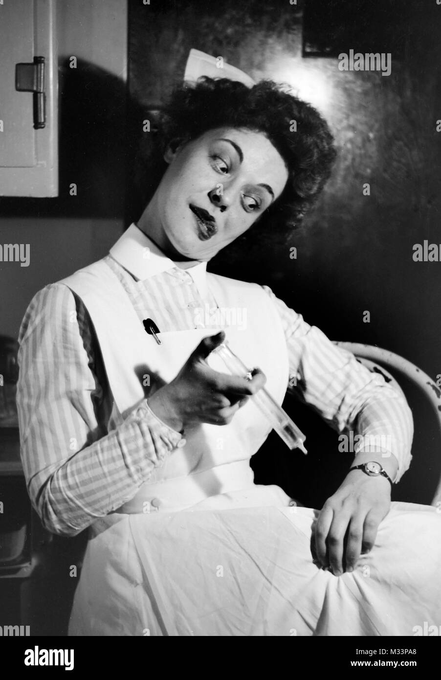 Ein goofy Krankenschwester inoculates sich spielerisch auf der Suche nach Humor, Ca. 1910. Stockfoto