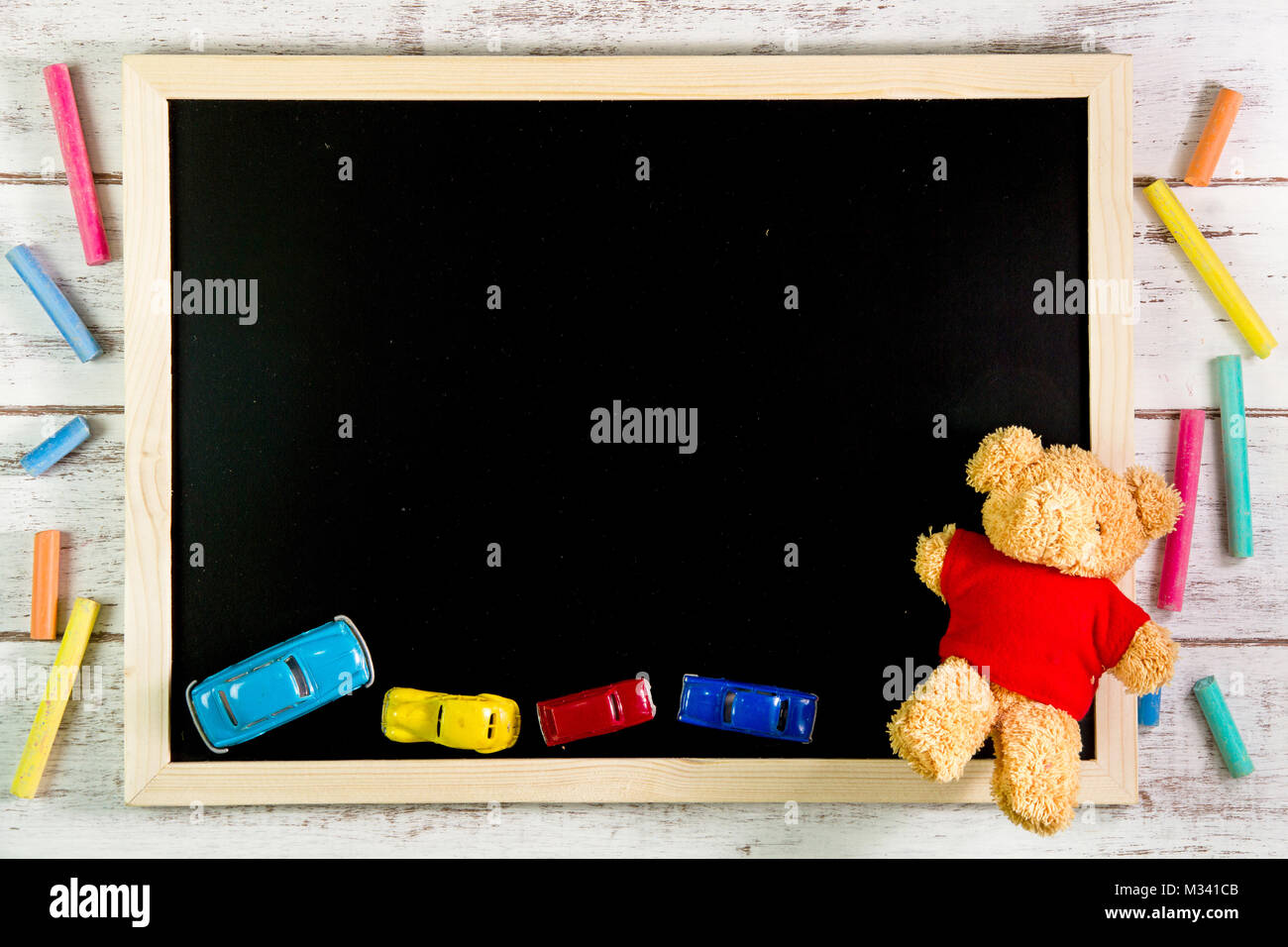 Leere Tafel, Teddybären und Auto Spielzeug auf Holztisch. Vorlage mock up  für das Hinzufügen Ihres Designs und der Platz neben Rahmen für das  Hinzufügen von mehr Text Stockfotografie - Alamy