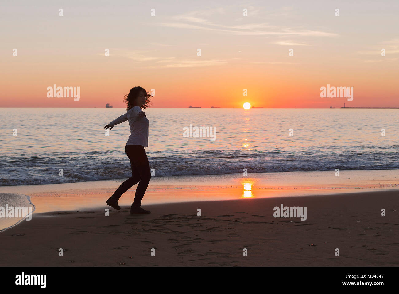 Frau tanzen am Strand bei Sonnenuntergang, Andalusien, Spanien Stockfoto