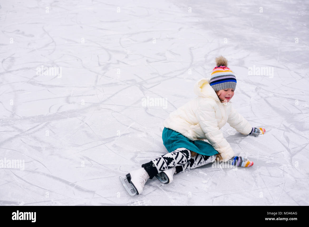 Mädchen, über Eis gefallen Skaten hat Stockfoto