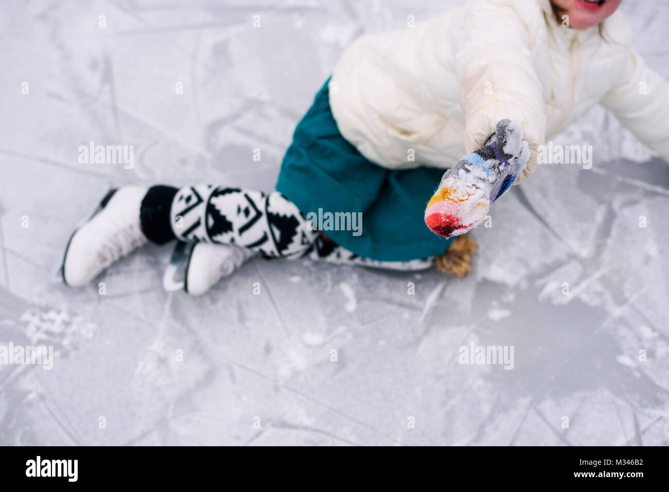 Mädchen, über Eis gefallen Skaten hat Stockfoto