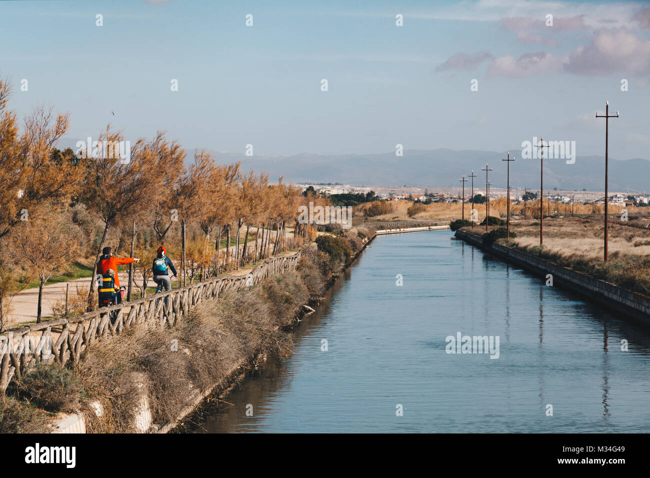 Ein biker Familie laufen entlang des Kanals auf der Molentargius Regional Park - Sardinien Italien. Stockfoto