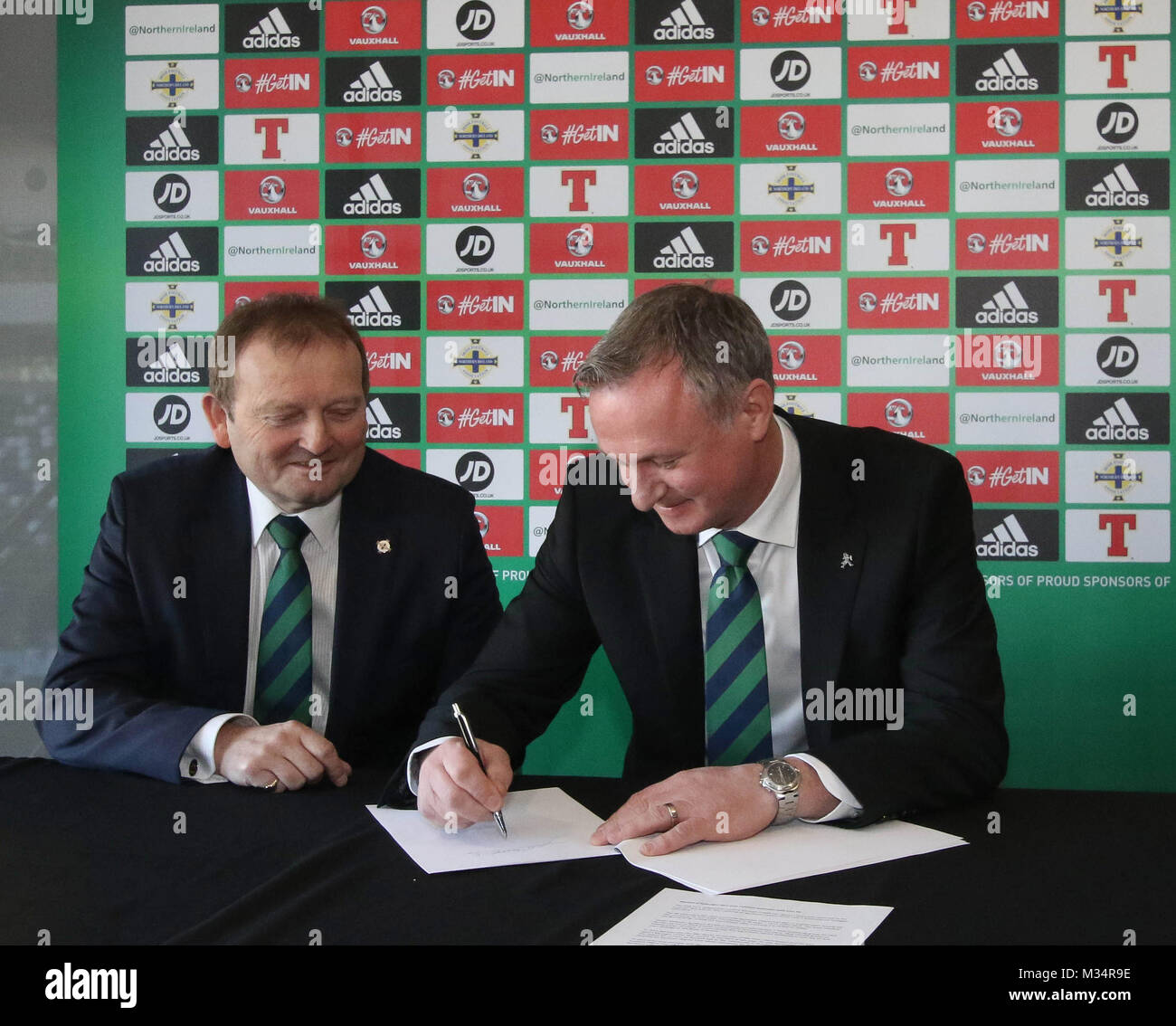 Belfast, UK. 9 Feb, 2018. Nationale Fußball-Stadion im Windsor Park, Belfast, Nordirland. Die Irish Football Association heute offiziell bekannt gegeben, dass Nordirland Manager Michael O'Neill eine vierjährige Vertragsverlängerung unterzeichnet hatte. Michael O'Neill (rechts) setzt Stift zu Papier mit Irish Football Association Präsident David Martin neben ihm. Quelle: David Hunter/Alamy Leben Nachrichten. Stockfoto