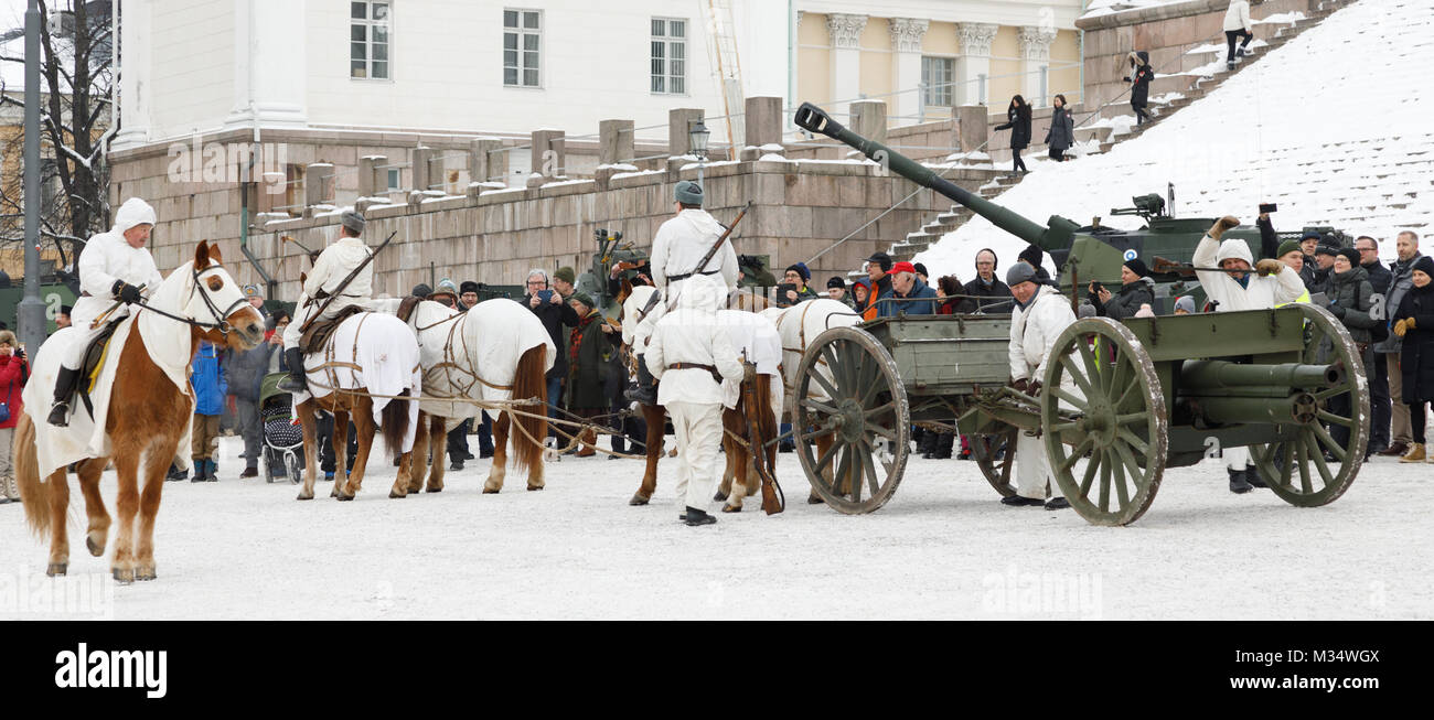 Helsinki, Finnland. 8 Feb, 2018. An die 100 Jahre Geschichte der Artillerie in unabhängigen Finnland gedenken, einer öffentlichen Veranstaltung wurde auf dem Senatsplatz in Helsinki am 9. Februar 2018 angeordnet. Es war eine Anzeige der heutigen Anlagen, plus ein Re-enactment von einem Pferd-driven Field Artillery Stück in eine Schussposition angetrieben. Die Pferde sowie das Feuern Crew sind tragen weiße snow Camouflage, wie in den Tagen des Winters Krieg 1939-40. Credit: Hannu Mononen/Alamy leben Nachrichten Stockfoto