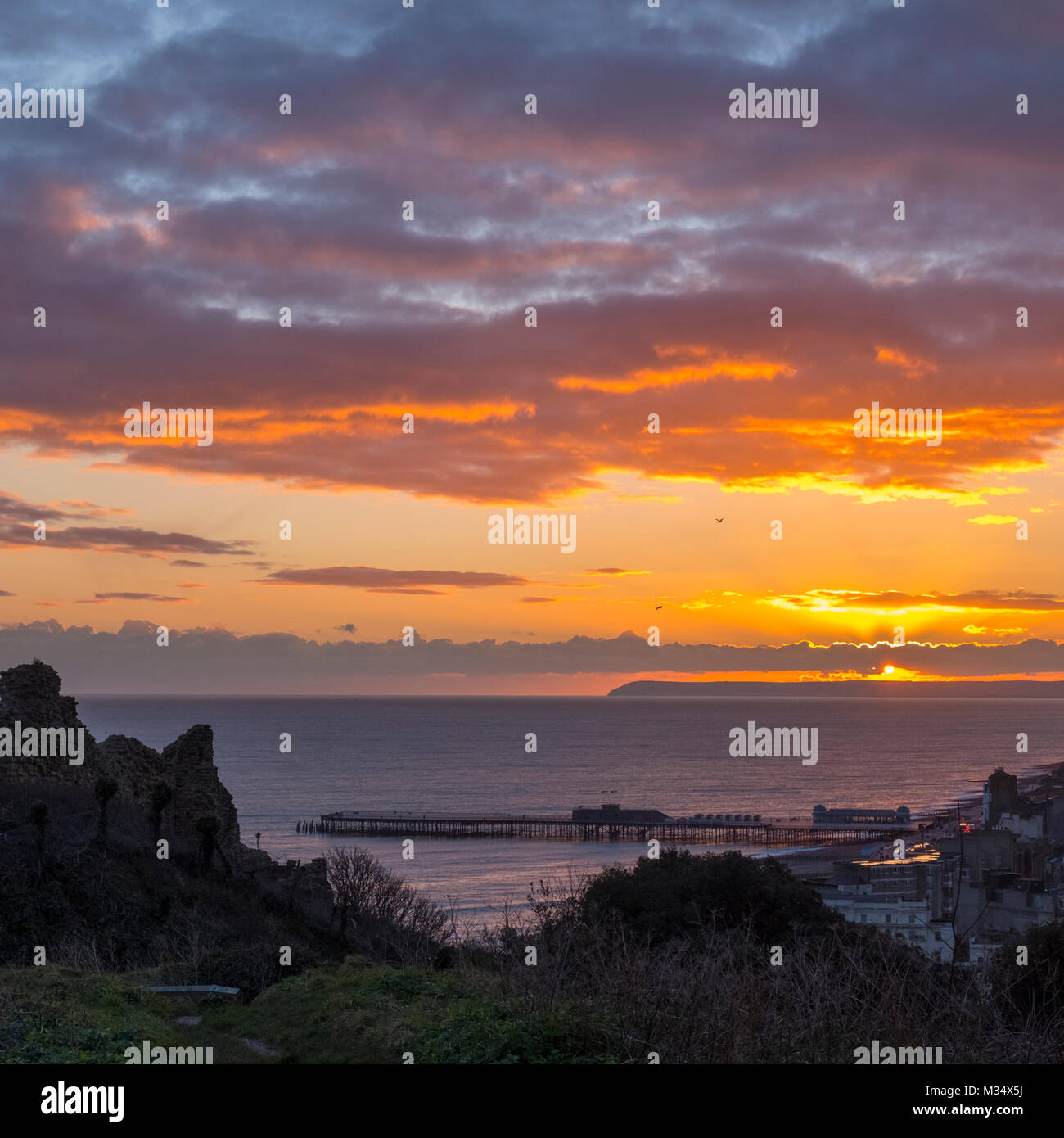 Hastings East Sussex UK. 9. Feb 2018. UK Wetter: Nach einem Tag der durchwachsenes Wetter, Sonnenschein, Regen und Schneeregen, einem schönen Sonnenuntergang zu ende der Tag, Blick von der Burg, über das Meer bis nach Hastings neue Pier und darüber hinaus zu Beachy Head. Stockfoto