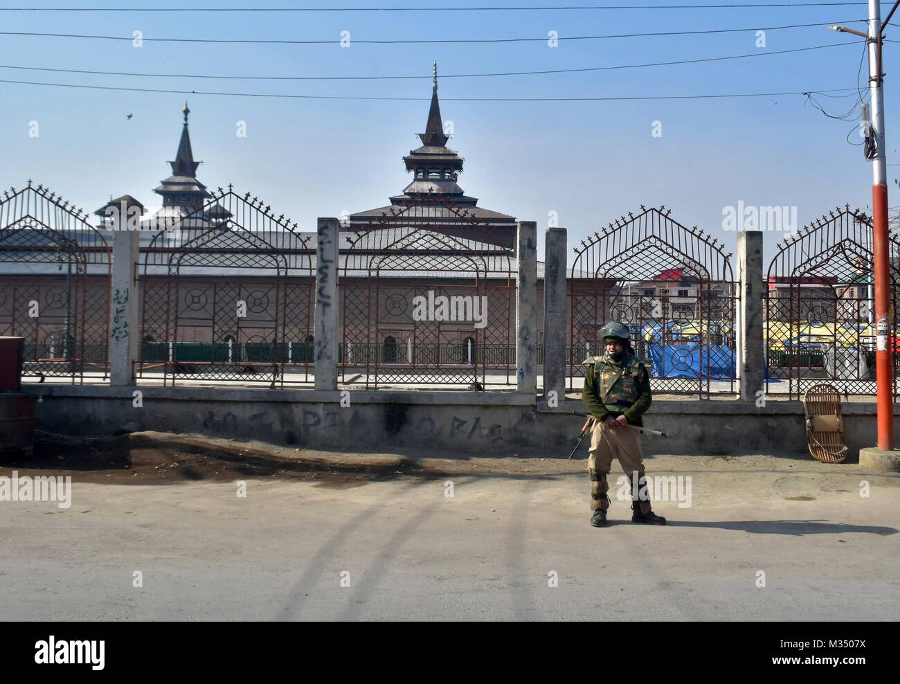 Srinagar, Indien. 9 Feb, 2018. Ein indischer Polizist wacht außerhalb der historischen Moschee während der Ausgangssperre in Srinagar. Behörden auferlegten Beschränkungen in einigen Teilen von Srinagar am Freitag während eines Streiks der Separatisten bezeichnet die Ausführung Jahrestag der Afzal Guru, ein Mann, der verurteilt wurde, Kaschmir und Todesurteil wegen seiner angeblichen Rolle im Jahr 2001 Angriff auf indische Parlament zu markieren. Credit: Saqib Majeed/SOPA/ZUMA Draht/Alamy leben Nachrichten Stockfoto