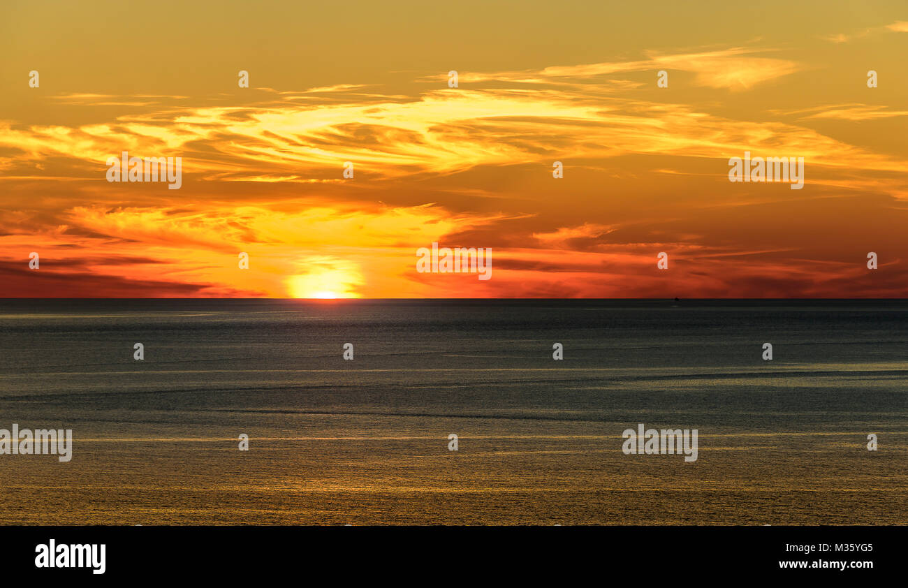 Stilisierte abstrakte Landschaft seascape Sonnenuntergang lange Belichtung mit Wolken unter verschiedenen Schattierungen von Blau, Orange, Gelb und Rot. Stockfoto