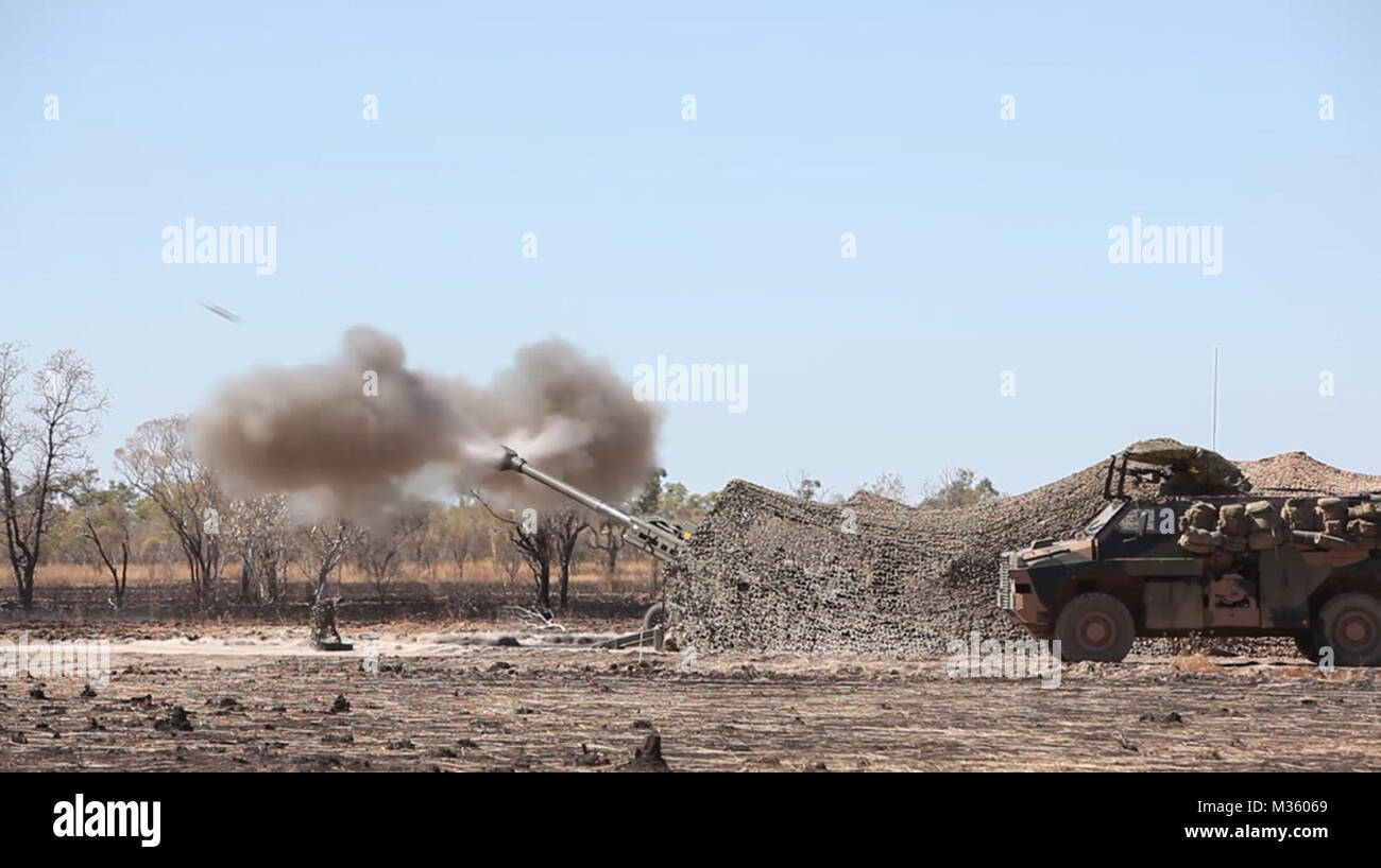 M777A2 lightweight 155 mm Haubitze mit 101 Batterie, 8./12 Regiment, Royal Australian Artillerie, der Australischen Armee, Brände ein Projektil zur Unterstützung eines US Marine Corps Air Assault Kurs Juni 29 im Feld Bradshaw, Northern Territory, Australien. Die AAC wurde eine bilaterale kombinierte Waffen Schulungsveranstaltung, die kombiniert leichte Infanterie, Indirektes Feuer Waffensysteme und die Vermögensgegenstände zu erfassen und durch ein mock Feind Ziel kämpfen. Die Marine die Drehkraft - Darwin Bereitstellung ermöglicht die Marines zu effektiv trainieren, Übung, und arbeiten mit ihren australischen Partnern verbessern Stockfoto