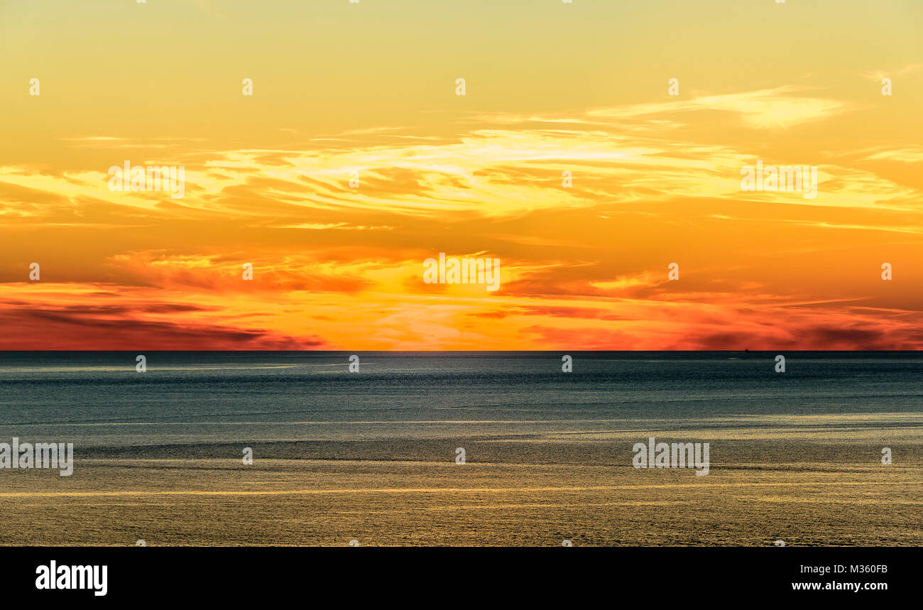 Stilisierte abstrakte Landschaft seascape Sonnenuntergang lange Belichtung mit Wolken unter verschiedenen Schattierungen von Blau, Orange, Gelb und Rot. Stockfoto