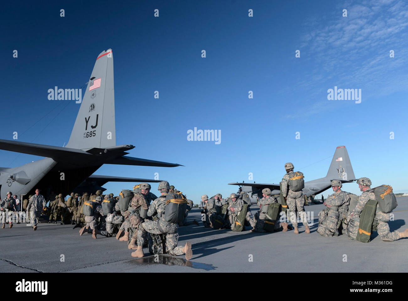Us-Soldaten mit der 1 Battalion (Airborne), 501 Infanterie Regiment, und die Mitglieder der Japan Masse Verteidigung-kraft warten, Vorstand der C-130 Hercules von Yokota Air Base, Japan, während Rot Flag-Alaska bei Joint Base Elmendorf-Richardson, Alaska, 12.08.2015. Mehr als 60 US-Soldaten und mehr als 20 JGSDF Mitglieder sprang aus mehreren C-130 Hercules während des Trainings. Mehr als 20 alliierten Länder in Rot Flag-Alaska seit seiner Konzeption, Verbesserung der Integration, Interoperabilität und interkulturelle Kompetenz teilgenommen haben. (U.S. Air Force Foto: Staff Sgt. Cody H. Ramirez/R Stockfoto